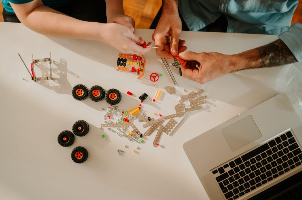 two individuals building a mini vehicle