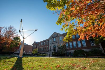 engineering castleman building in the fall with leaves on the ground and sun in the background